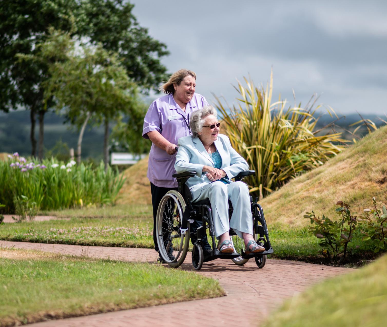 Hospice Isle of Man nurse pushing patient in wheelchair