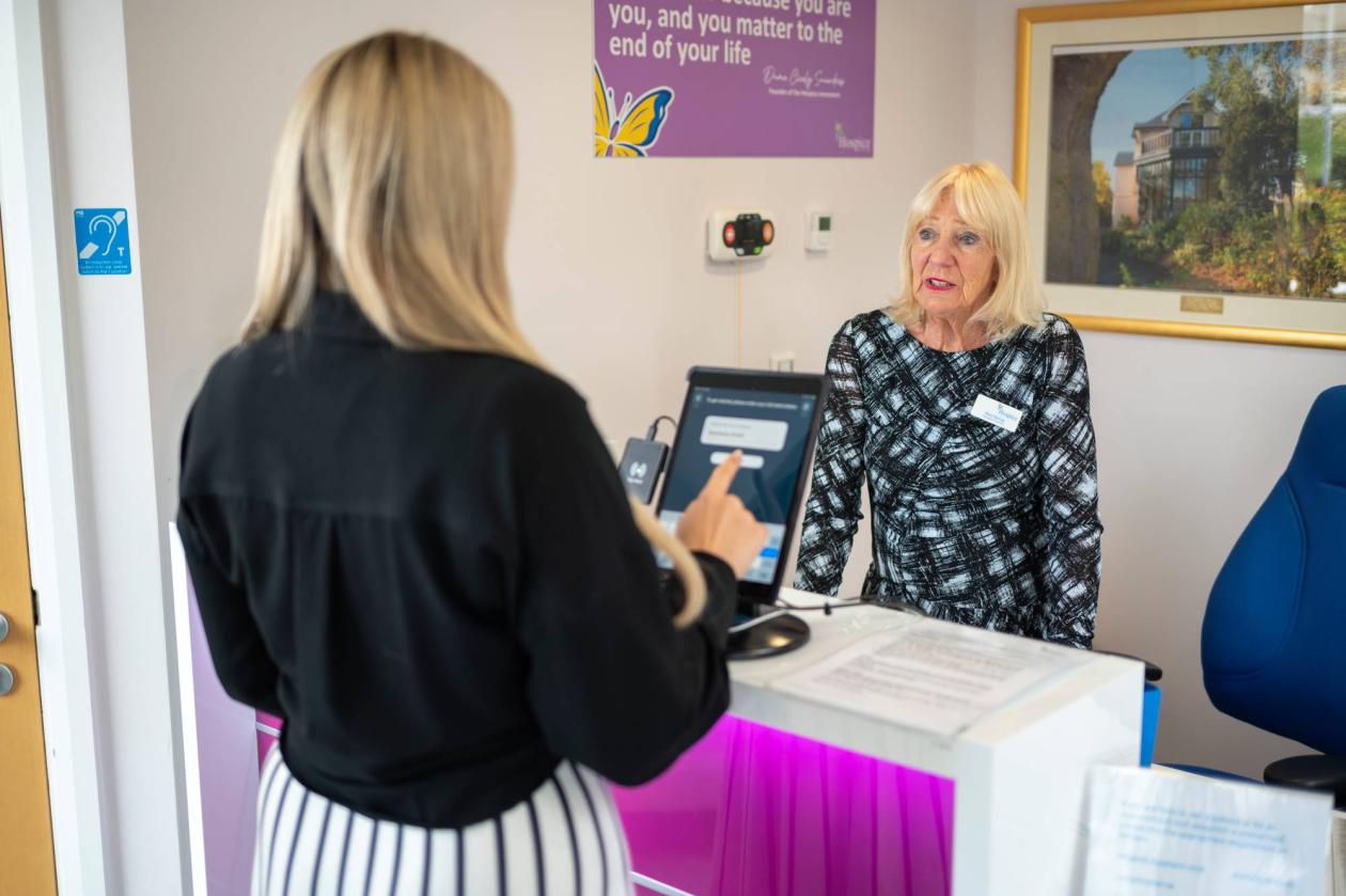 A women signing in at the reception desk